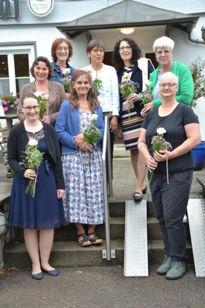 Ein Gruppenbild der Absolventinnen, die jeweils ein Blumensträußchen in Händen halten.