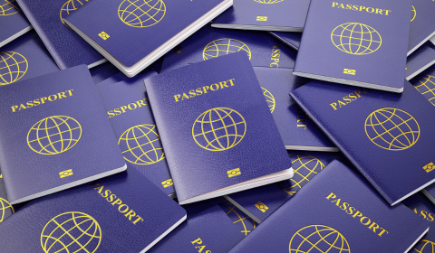 Neuer Reisepass? - Neue Niederlassungserlaubnis! ein Haufen generischer Passbüchlein durcheinander geworfen