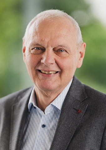 Franz Baur Franz Baur, ein Mann gehobenen Alters mit hoher Stirn und weißem kurzem Haar. Er trägt weder Bart noch Brille. Er trägt ein graues Jackett und darunter ein helles Hemd.